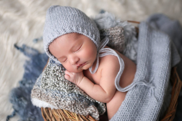 Newborn baby boy in native american weave basket. 